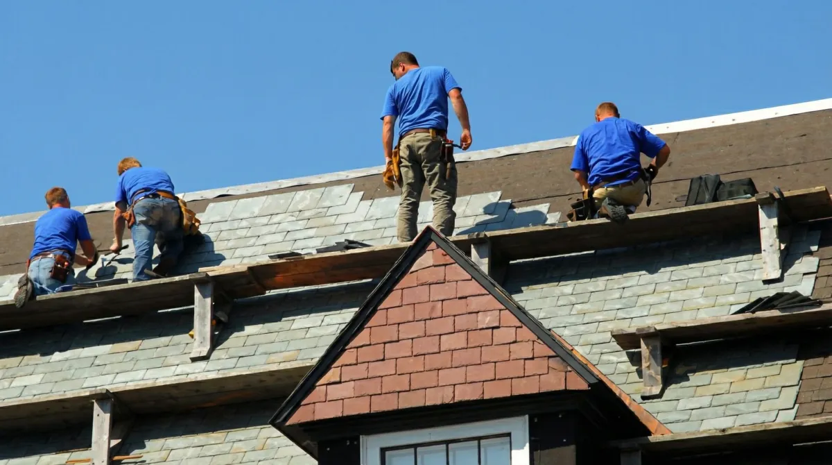 Roof replacement in progress with a team of professional contractors installing new shingles on a residential home in Houston, TX